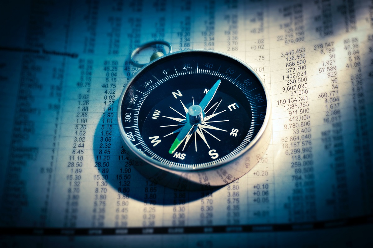 Compass on the financial section of a newspaper