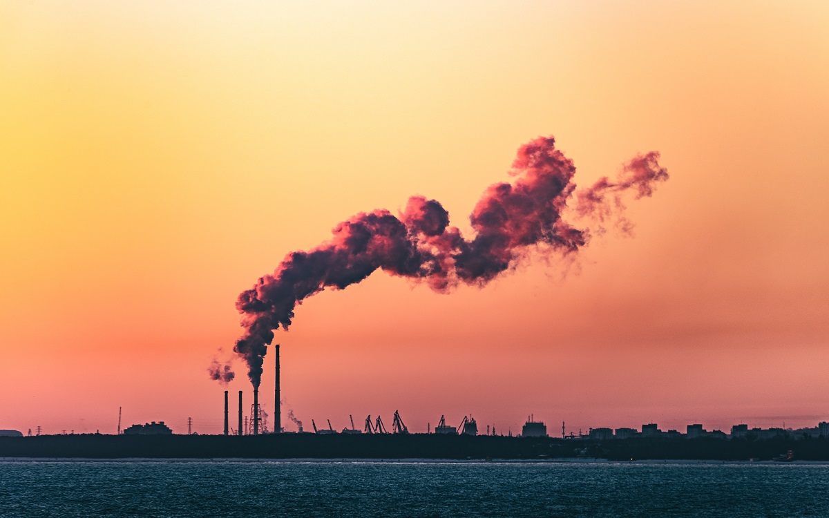 Smokestack with large clouds at sunset